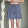 Person wearing a blue striped skirt with a white background