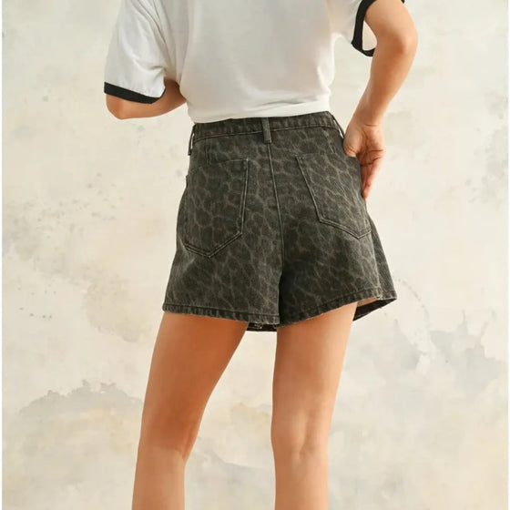 Person wearing dark denim shorts with a white background