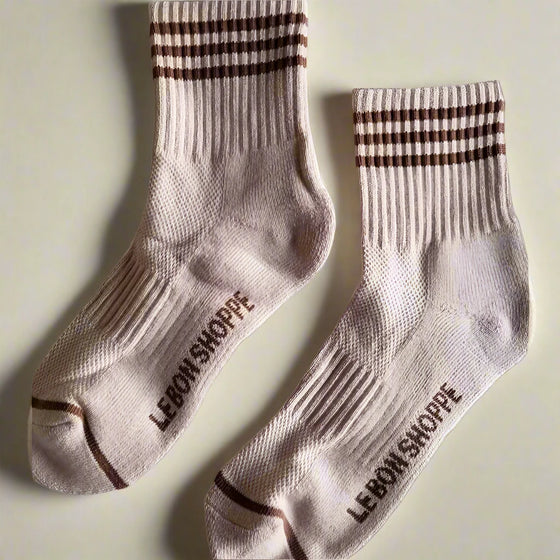 Pair of beige socks with brown accents and 'Le Bon Shoppe' branding on a light gray background.